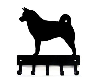 A metal key holder or dog leash hanger with a dog on top and 5 hooks below