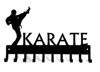 A medal hanger with 10 hooks. Cut from the metal is a Karate figure in a high kick pose, and the word KARATE is cut out.