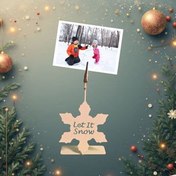 Decorative snowflake holder with 'Let It Snow' text on a festive background with Christmas ornaments and a photo of two children in the snow.
