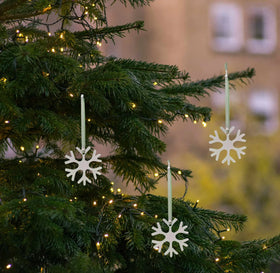 White metal snowflakes hanging on a Christmas tree
