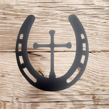 Black horseshoe with cross design on a wooden background