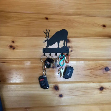 A key hanger with several keys and the silhouette of an elk
