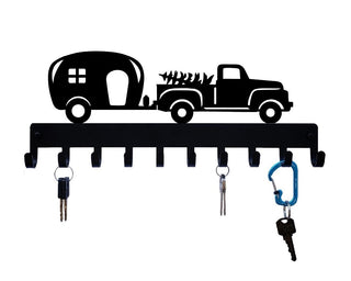 A key holder with cut out design of a camper pulled by a pickup truck. It has 10 hooks and keys are hanging from 3 of the hooks.