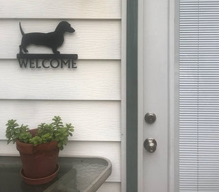 A Dachshund dog welcome sign on the side of a house