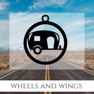 An open road with blue sky and mountains. An image of a camper on a key chain. The words Wheels and Wings.