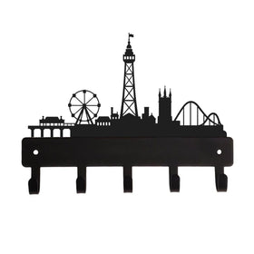 Black metal wall hook rack shaped like a seaside skyline with a Ferris wheel, Blackpool Tower, church, roller coaster, and pier, shown on a plain white background.