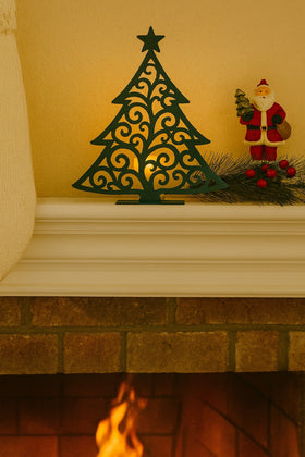 Decorative Christmas tree and Santa figure on a mantelpiece with a warm glow.