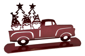 3 gnomes in the back of a red pickup truck