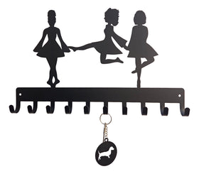 Decorative key holder with silhouettes of three Irish step dancers and a keychain attached.