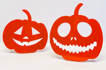 Two orange paper jack-o'-lanterns with white faces on a white background