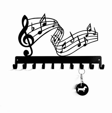Decorative key holder with musical notes design on a white background
