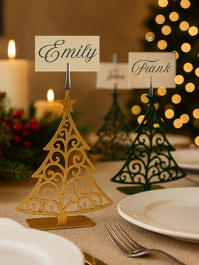 Decorative table name cards on Christmas tree stands with a festive background.