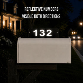 Reflective house numbers '132' on a mailbox at night with visible text 'REFLECTIVE NUMBERS VISIBLE BOTH DIRECTIONS'.