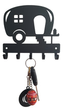 Camper-shaped black key holder with a set of keys and a red decorative egg keychain.