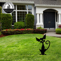 Metal cat sculpture on a lawn in front of a house . Halloween.
