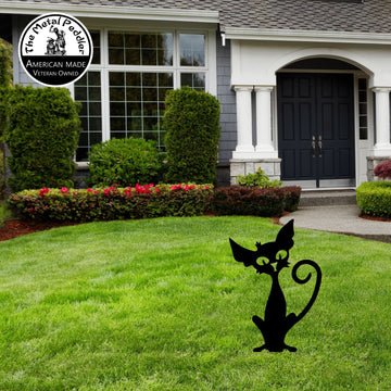 Metal cat sculpture on a lawn in front of a house . Halloween.