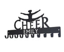 A medal hanger with a cheerleader doing a split jump over the word CHEER. It has the name EMILY cut into the bar. It has 10 hooks for hanging medals.