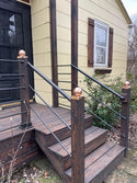 4x4 copper post cap on a stair rail post up to a porch