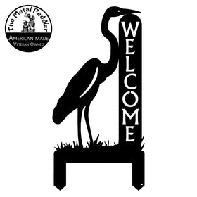 Decorative metal sign with a heron silhouette and 'Welcome' text, branded 'The Metal Paddler'.