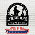 Decorative sign with 'Freedom Isn't Free' and 'Made in USA' text on a white brick background