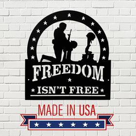 Decorative sign with 'Freedom Isn't Free' and 'Made in USA' text on a white brick background