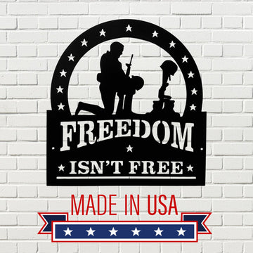 Decorative sign with 'Freedom Isn't Free' and 'Made in USA' text on a white brick background