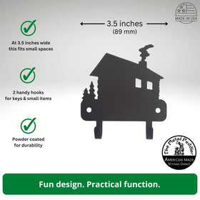 Metal wall hook with house design, featuring text on dimensions and features, on a gray background.
