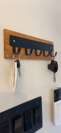 A simple key rack with 5 hooks for hanging keys on a wall
