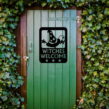 Green door with 'Witches Welcome' sign surrounded by ivy